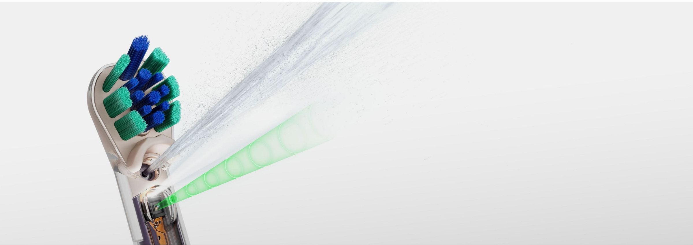 Tête de brosse Dyson CameraJet™ en gros plan sur fond blanc, projetant son jet d’eau conique et le faisceau vert de détection des espaces interdentaires.